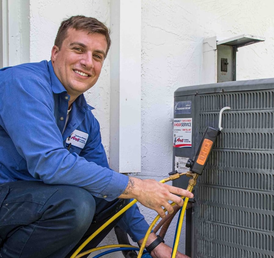 An Art Plumbing, Air Conditioning, and Electric technician working on an air conditioner